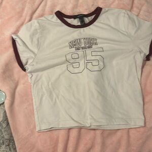White crop top with maroon details that says new york and the numbers 95